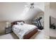 Attic bedroom with angled ceilings, a comfortable bed, skylight, and an exercise machine in the corner at 1887 Chamdun Pl, Brookhaven, GA 30341