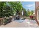 Spacious outdoor deck with a dining set, grill, and lush greenery, perfect for outdoor entertaining at 1887 Chamdun Pl, Brookhaven, GA 30341
