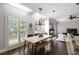 Bright dining area with skylights, large windows, a modern table, and views into the living area and kitchen at 1887 Chamdun Pl, Brookhaven, GA 30341