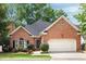 Charming brick home featuring a two-car garage, manicured landscaping, and a classic design at 1887 Chamdun Pl, Brookhaven, GA 30341