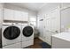 Functional laundry room featuring a side-by-side washer and dryer, storage cabinets, and a utility sink at 1887 Chamdun Pl, Brookhaven, GA 30341
