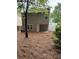 View of the home's back exterior, showing a small covered patio and yard covered in pine straw at 218 Osmanthus Way, Canton, GA 30114
