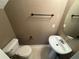 A compact bathroom showcases a toilet, pedestal sink, and an oval mirror with a towel rack at 218 Osmanthus Way, Canton, GA 30114