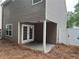 Covered back patio with access to backyard, featuring painted posts and neutral siding at 218 Osmanthus Way, Canton, GA 30114