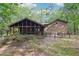 A wide backyard view that shows the screened-in porch with wooded surroundings at 402 Summit Ridge Ter, Lawrenceville, GA 30046