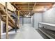 Unfinished basement featuring exposed wooden beams, stairs, and cement walls at 402 Summit Ridge Ter, Lawrenceville, GA 30046