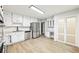 Beautiful white kitchen with stainless steel appliances, granite countertops, and wood grain tile flooring at 402 Summit Ridge Ter, Lawrenceville, GA 30046