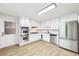 Spacious white kitchen equipped with stainless steel appliances, granite countertops, and tile floors at 402 Summit Ridge Ter, Lawrenceville, GA 30046
