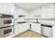 Modern white kitchen features stainless steel appliances and granite countertops providing ample workspace at 402 Summit Ridge Ter, Lawrenceville, GA 30046
