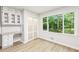 Home office area with built-in desk, cabinets, and a large window overlooking a wooded backyard at 402 Summit Ridge Ter, Lawrenceville, GA 30046