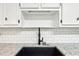 Close up of a kitchen sink, granite countertops, and subway tile backsplash at 402 Summit Ridge Ter, Lawrenceville, GA 30046