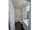 Clean bathroom with a tub/shower combo, modern vanity, fresh paint, and stylish wood-look flooring at 7797 Sudbury Cir, Covington, GA 30014