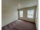Bedroom featuring neutral carpet, two windows, and white trim and doors at 7797 Sudbury Cir, Covington, GA 30014