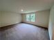 Bonus room with two windows allowing natural light, neutral paint, and carpeted flooring at 7797 Sudbury Cir, Covington, GA 30014
