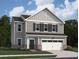 Charming two-story home featuring gray siding, black shutters, and a two-car garage at 7797 Sudbury Cir, Covington, GA 30014