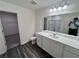 Modern bathroom features dual sinks, white cabinets, and a large mirror at 7791 Sudbury Cir, Covington, GA 30014