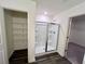 Clean bathroom with glass-enclosed shower and shelving in walk-in closet at 7791 Sudbury Cir, Covington, GA 30014