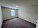 A light, carpeted bedroom with a large window and closet at 7791 Sudbury Cir, Covington, GA 30014