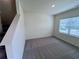 Cozy bedroom features neutral carpeting and a window bringing in natural light at 7791 Sudbury Cir, Covington, GA 30014