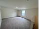 Bright bonus room featuring neutral walls, carpeted flooring, and natural light from a window at 7791 Sudbury Cir, Covington, GA 30014