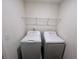 A well-lit laundry room with washer, dryer, and overhead storage at 7791 Sudbury Cir, Covington, GA 30014