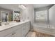 Bright bathroom features double vanity with white cabinets, tub, and a neutral color palette at 1452 Weatherbrook Cir, Lawrenceville, GA 30043