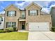 Inviting two-story home with a brick facade, landscaped yard, and a two-car garage at 1452 Weatherbrook Cir, Lawrenceville, GA 30043