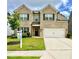 Welcoming two-story home with a well-kept lawn, brick front, and an attached two-car garage at 1452 Weatherbrook Cir, Lawrenceville, GA 30043