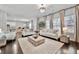 Bright living room with hardwood floors, white sofas, and a view of the open concept kitchen and dining area at 1452 Weatherbrook Cir, Lawrenceville, GA 30043