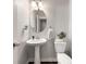 Clean and modern powder room with pedestal sink, oval mirror, and fresh decor, adding convenience for guests at 1452 Weatherbrook Cir, Lawrenceville, GA 30043