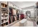 Spacious walk-in closet featuring custom shelving, racks, mirror and a padded bench at 1452 Weatherbrook Cir, Lawrenceville, GA 30043