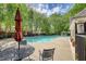 Community pool featuring an umbrella table, seating, and lush green surroundings at 2160 Dillard Xing, Tucker, GA 30084
