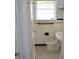 Cozy bathroom featuring white tiling with black accents and patterned flooring at 2381 Eastway Rd, Decatur, GA 30033