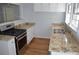 Kitchen with granite countertops, stainless appliances, and hardwood floors at 2381 Eastway Rd, Decatur, GA 30033