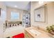 Bright bathroom featuring a soaking tub, shower, natural stone accents, and vanity at 3099 Regency Park Dr, Lithonia, GA 30038
