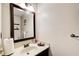 Cozy half-bathroom featuring a wood framed mirror, dark vanity, and neutral wall color at 3099 Regency Park Dr, Lithonia, GA 30038