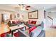 Open-concept living room with hardwood floors, neutral-toned furniture with red accents, and dining room view at 3099 Regency Park Dr, Lithonia, GA 30038