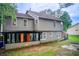 Rear exterior view showcasing a two-story home with a covered sunroom, a well-maintained yard, and mature trees at 3099 Regency Park Dr, Lithonia, GA 30038