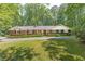 Charming brick ranch with a manicured lawn, mature trees, and a welcoming front porch at 544 W Macedonia Church Rd, Oxford, GA 30054