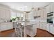 Bright kitchen features white cabinets, stainless steel appliances, granite countertops, and a center island with bar stool seating at 1481 Highway 85 Connector, Brooks, GA 30205