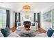 Cozy living room with fireplace, blue accent pillows, large windows, and a decorative chandelier for a luxurious feel at 1481 Highway 85 Connector, Brooks, GA 30205