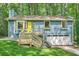 Charming blue home with a bright yellow door and a wooden porch surrounded by lush greenery at 2336 Vistamont Dr, Decatur, GA 30033
