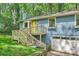 Blue home featuring a wooden porch and a convenient garage, nestled in a serene, wooded setting at 2336 Vistamont Dr, Decatur, GA 30033