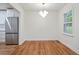 Bright dining room with hardwood floors, modern light fixture and stainless refrigerator at 3480 Mount Olive Rd, Atlanta, GA 30344