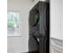 Laundry closet featuring a black stackable washer and dryer near a window at 3480 Mount Olive Rd, Atlanta, GA 30344