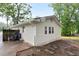 Rear view of the house showing updated siding and roof with a paved walkway and mature trees in the backyard at 3480 Mount Olive Rd, Atlanta, GA 30344