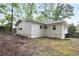 Back exterior view of house featuring new siding, new roof and updated windows, nestled on a treed lot at 3480 Mount Olive Rd, Atlanta, GA 30344