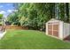 Lush green backyard with a shed, play set, and patio area with outdoor seating at 350 Medridge Dr, Johns Creek, GA 30022