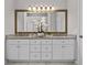 Bathroom featuring a double vanity with granite countertops and a decorative mirror at 350 Medridge Dr, Johns Creek, GA 30022