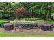 Stone sign for Medlock Bridge community entrance is beautifully landscaped with colorful plants and trees at 350 Medridge Dr, Johns Creek, GA 30022